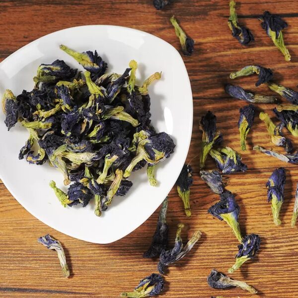 Dried butterfly pea flowers on a white plate – natural herbal ingredients for blue tea