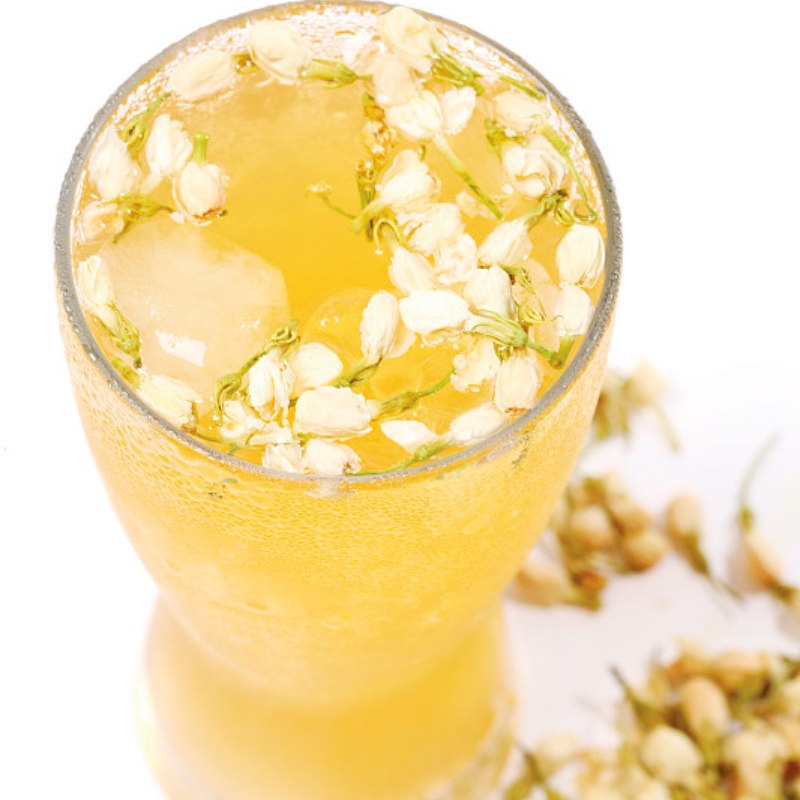 Refreshing jasmine tea in a clear glass with fresh jasmine blossoms, featuring a vibrant and bright garden background – natural and floral tea aesthetic.