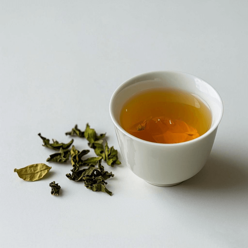 A steaming cup of traditional oolong tea placed on a wooden table with loose tea leaves beside it, visually representing the daily health benefits oolong tea offers such as metabolism support and improved focus.