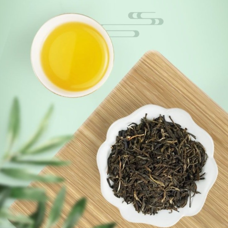 Top view of a cup of brewed jasmine tea and loose leaves on a wooden tray, representing the premium quality of the best jasmine tea brands available for health-conscious tea lovers.